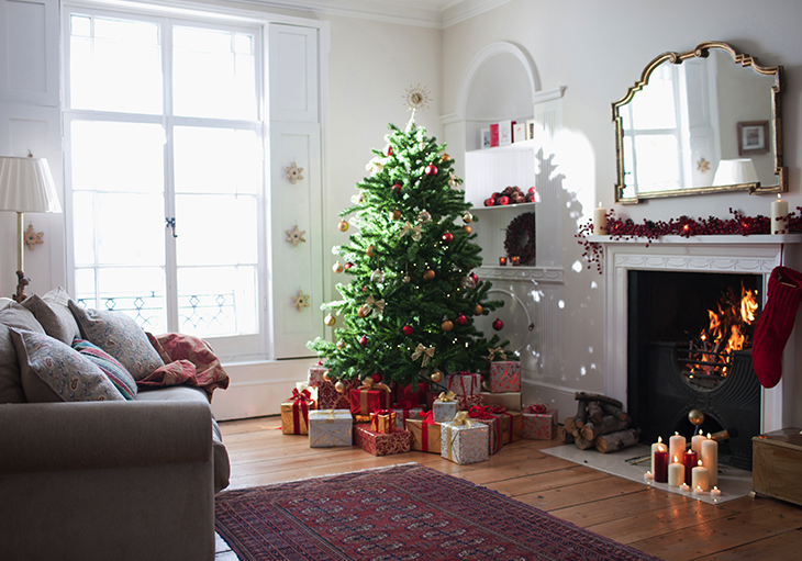 A decorated Christmas tree sits in the corner of a room, along with other holiday decorations.