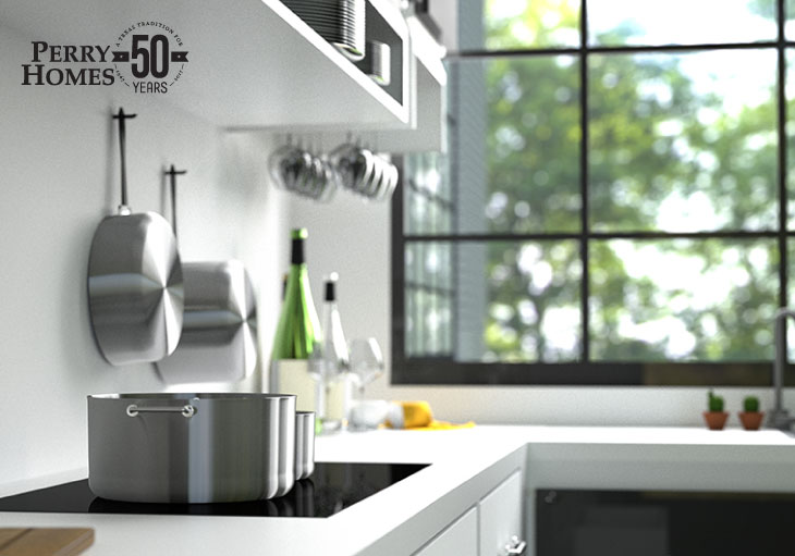 modern white kitchen with stainless steel pots and pans on black glass cooktop