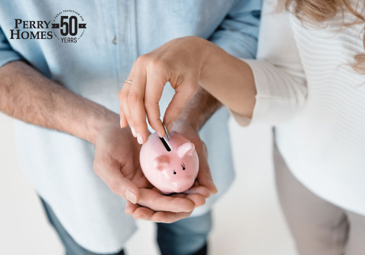 man holds small pink piggy bank as woman drops a quarter into it