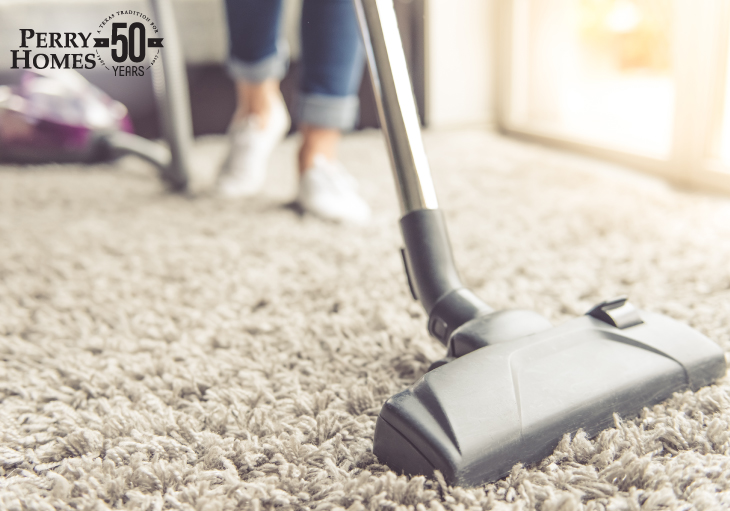 Cropped image of beautiful young woman using a vacuum cleaner while cleaning carpet in the house