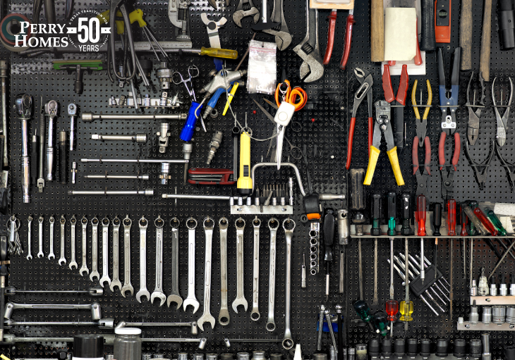 black pegboard filled with a variety of tools including wrenches, pliers, screwdrivers and accessories