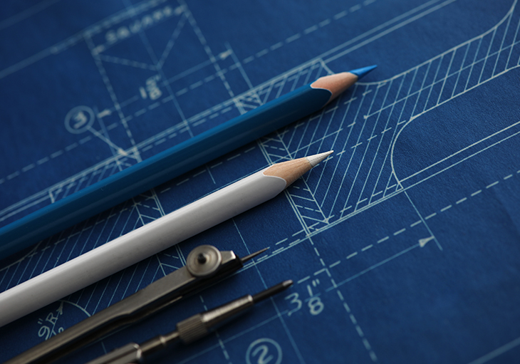 Two colored pencils lay on top of a blueprint.