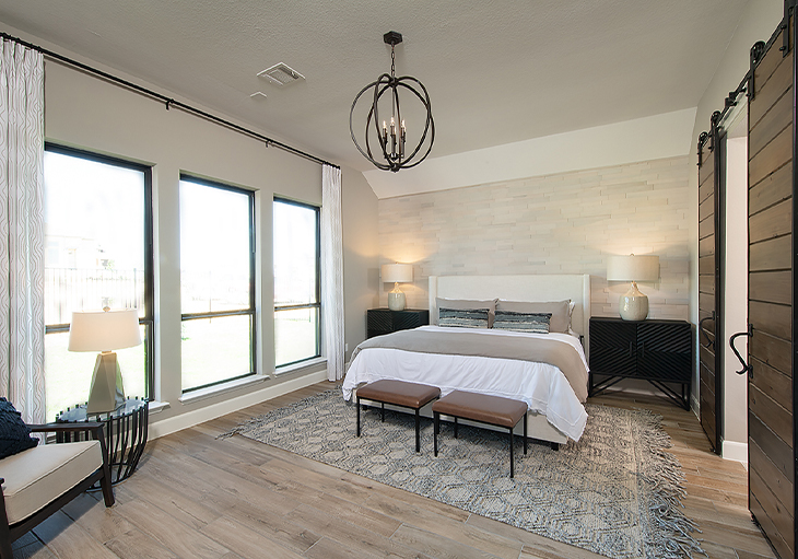 A primary bedroom features a wall of windows, a signature feature in every Perry Homes property.