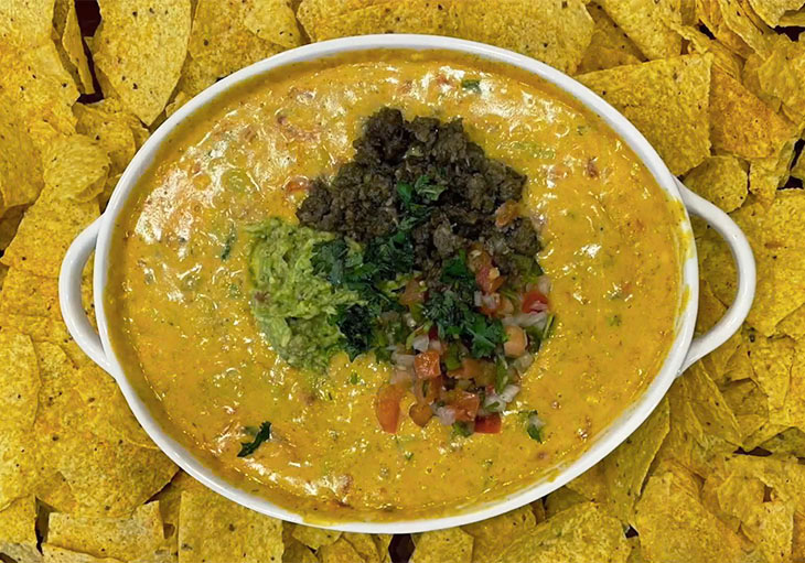 Bowl of queso dip and tortilla chips.