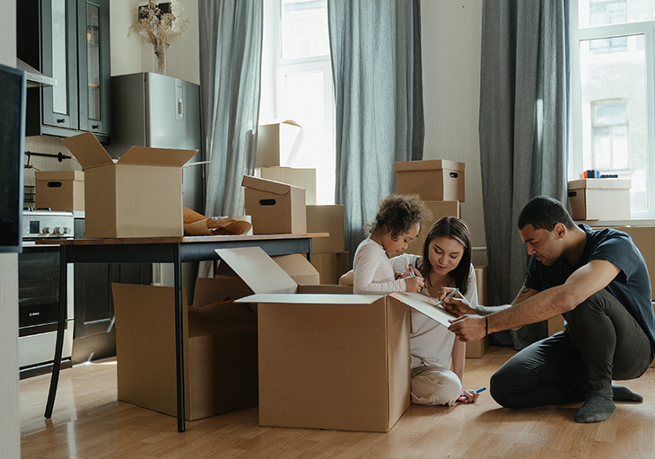 A family unpacks boxes in the kitchen of their new home.