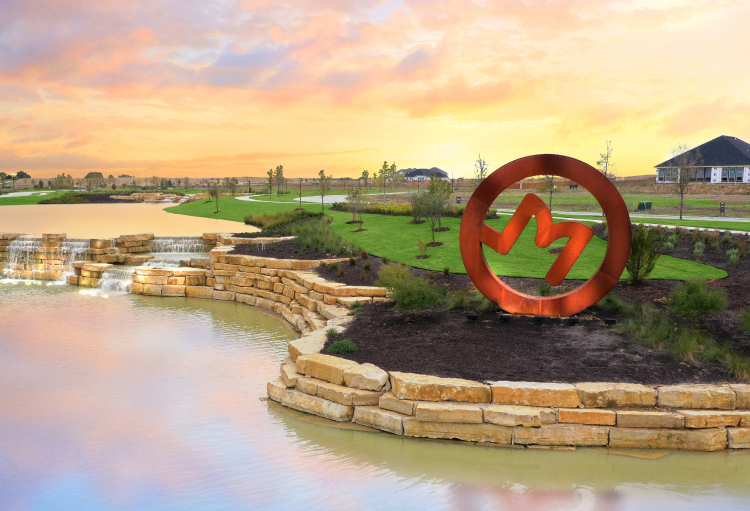 The front entrance of M3 Ranch includes a lake with a waterfall and green space